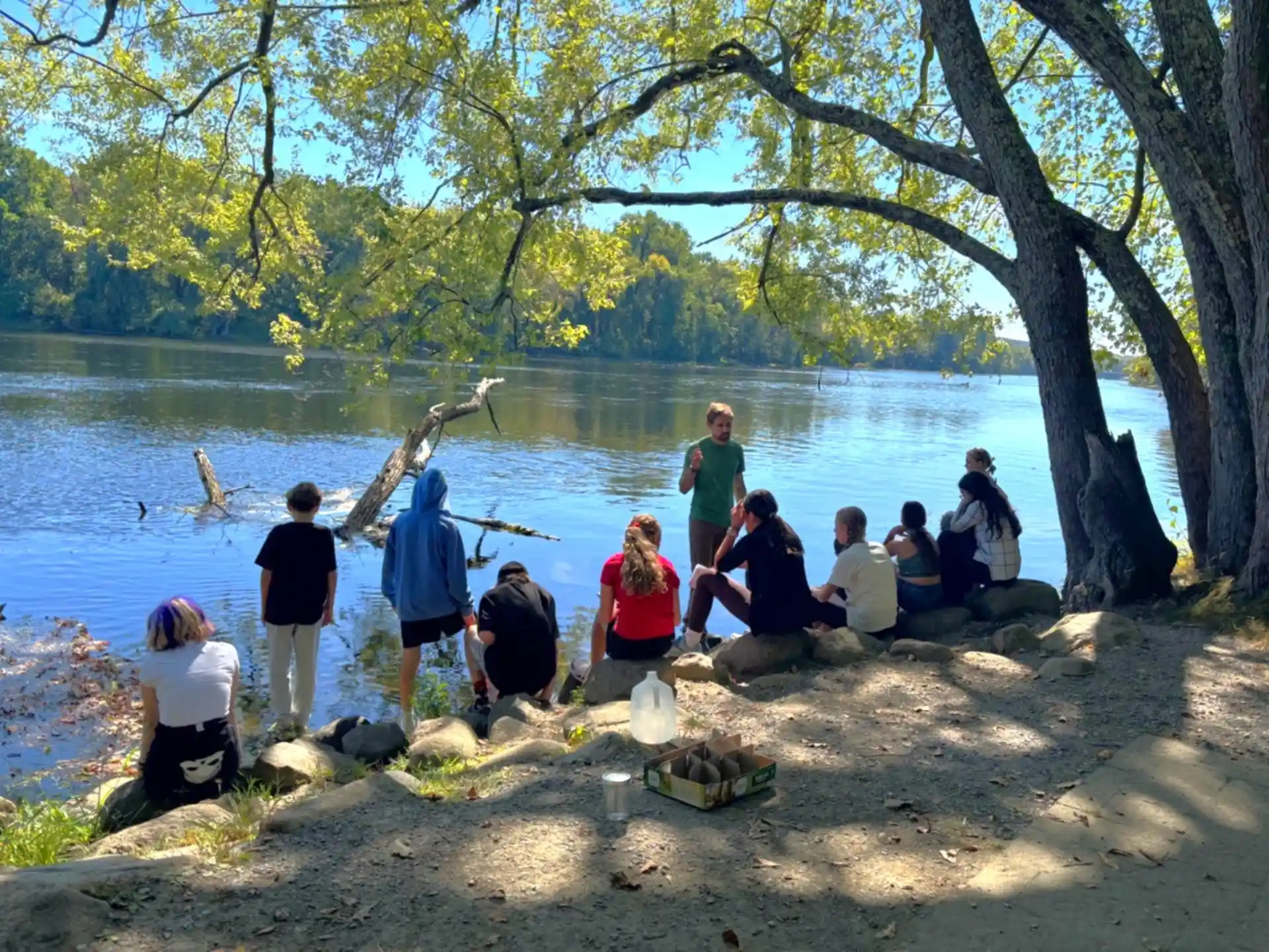 Students gathered by the river for an outdoor class lesson