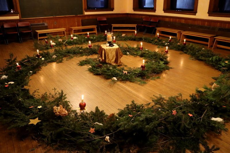 An Advent spiral of evergreens lit with candles