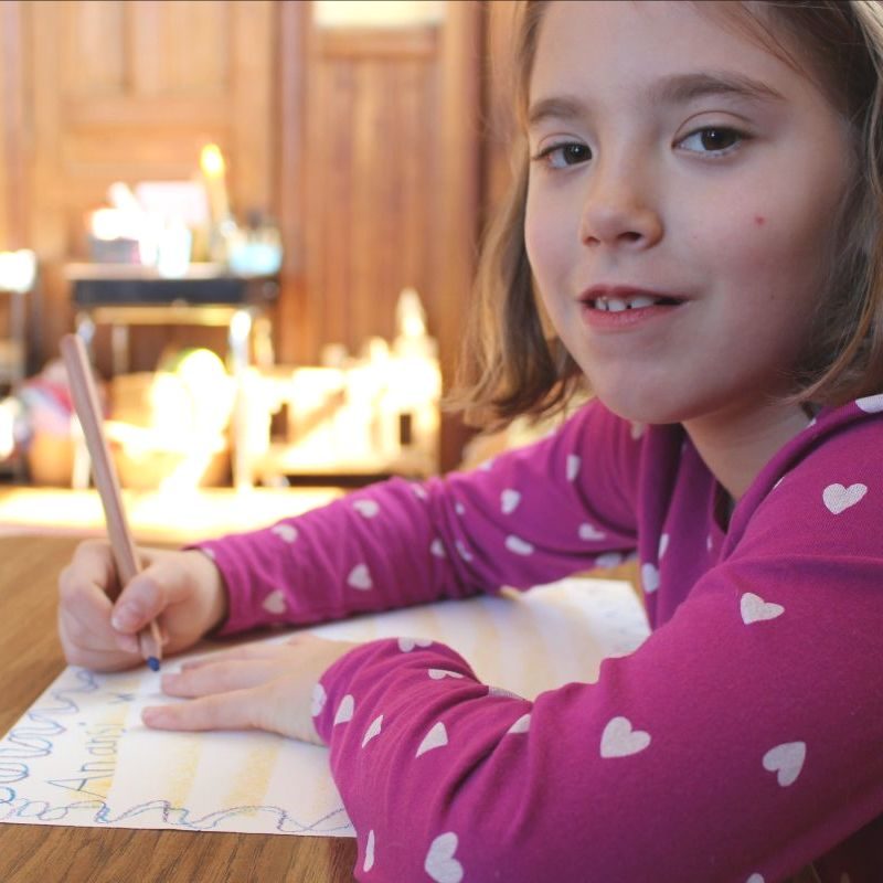 A student writing at her desk by candlelight