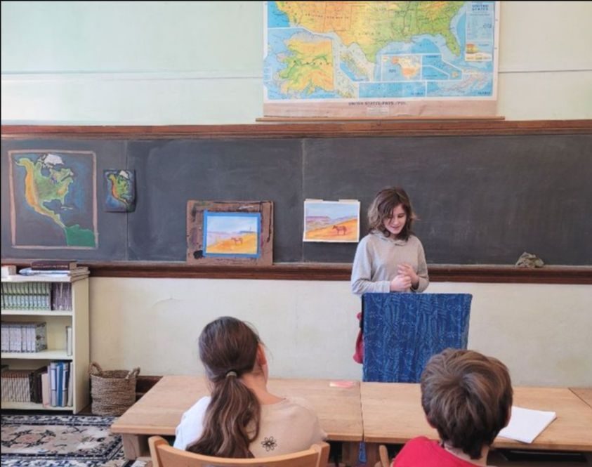 A teacher leading a geography lesson at the chalkboard