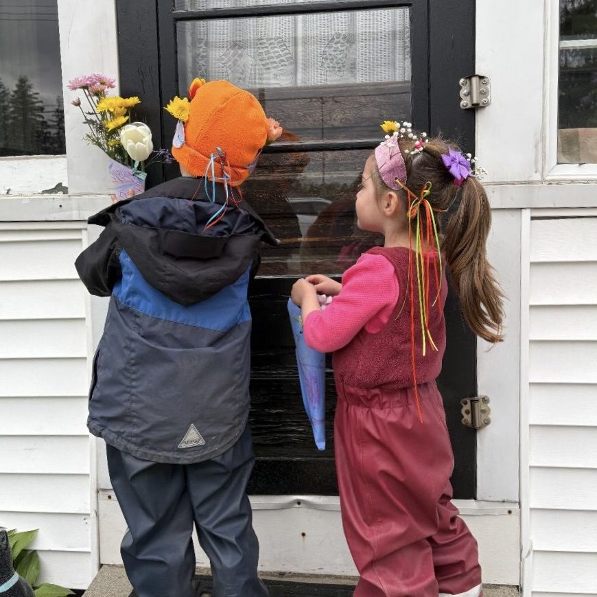 Young children in warm clothes delivering handmade baskets to a neighbor's door
