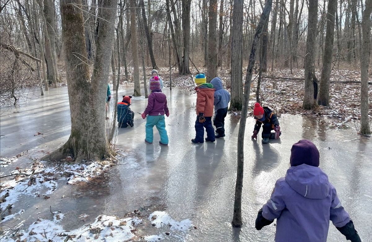 Children walking along a snowy woodland trail