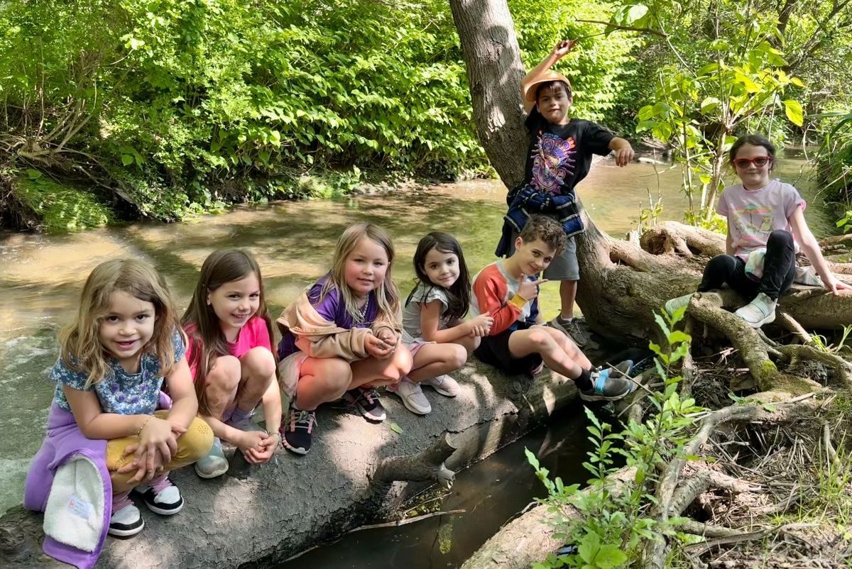 Children climbing on rocks beside a stream at a local park