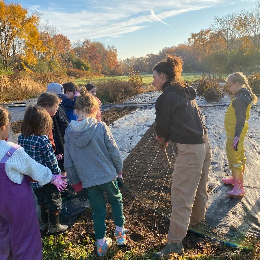 Students gathered along a river bank in autumn