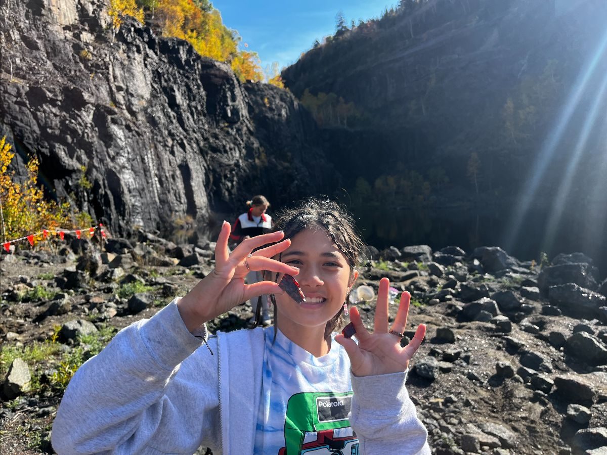 A student searching for gems at a rocky mine
